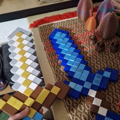 Pikselowe bloki w stylu Minecraft — miecze i inne elementy ułożone na dywanie