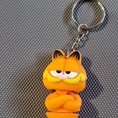 Breloczek Garfield z pomarańczowym kotem, brązowymi uszami i sennym wyrazem pyska